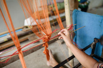 Midsection of person working on loom