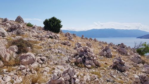 Rocks by sea against sky