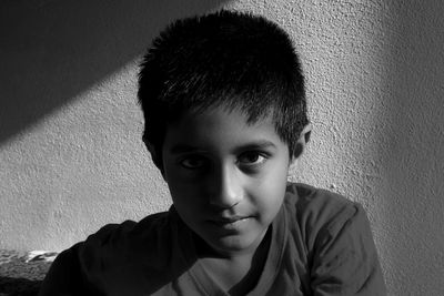 Close-up portrait of boy against wall