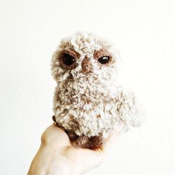 Cropped hand holding stuffed toy against white background