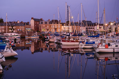 Sailboats moored in harbor