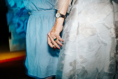 Midsection of woman holding cigarette by female