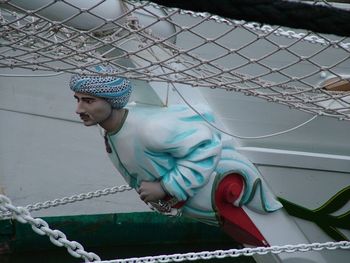 Full length of man looking at rope fence