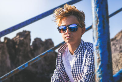 Portrait of young man wearing sunglasses against sky