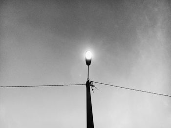 Low angle view of illuminated street light against sky