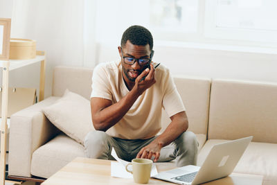 Young woman using laptop while sitting at home