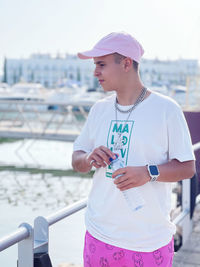 Boy standing by railing in city