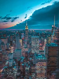 Aerial view of buildings in city against sky at dusk