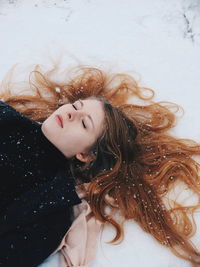 High angel view of woman lying on snow