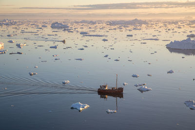 High angle view of boats in sea at sunset