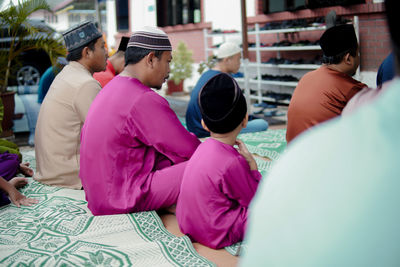 Rear view of people sitting in traditional clothing