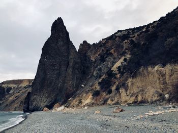 Rock formations by sea against sky