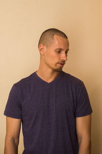 Portrait of young man standing against wall