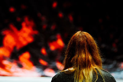 Rear view of blond woman looking at fire