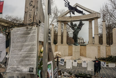 Statue in city against buildings