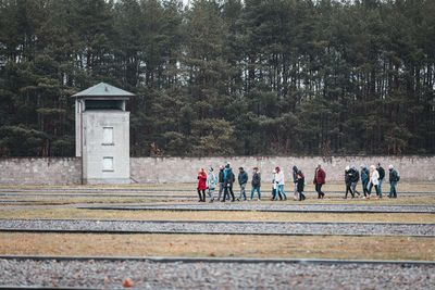 Group of people walking on road against trees