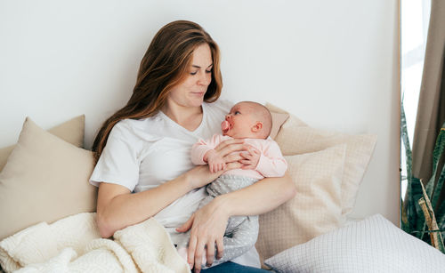 Young caucasian mother with a one-month baby in her arms.