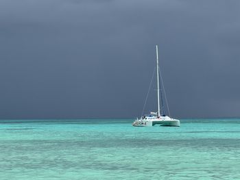 Sailboat sailing on sea against clear sky