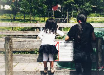 Rear view of friends standing on bench