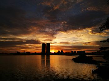 Scenic view of river against cloudy sky during sunset