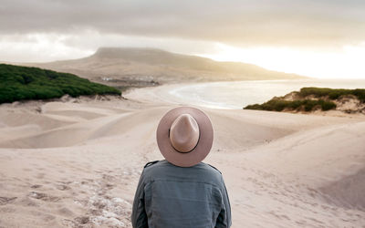 Rear view of man looking at desert against sky