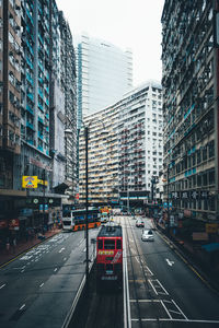 Cars on street in city against clear sky