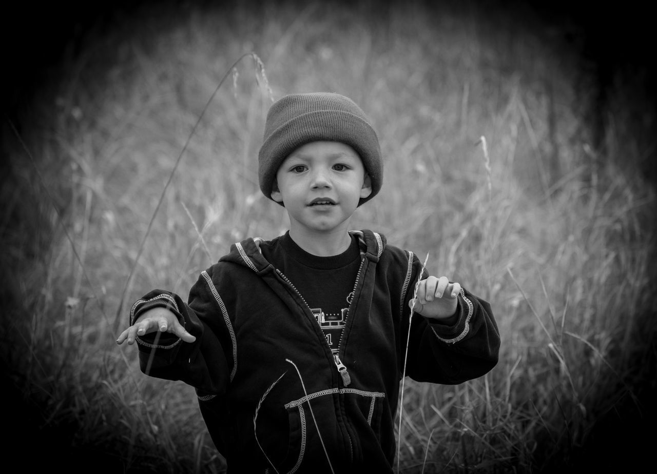 PORTRAIT OF BOY IN HAT STANDING AGAINST WALL