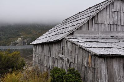 Exterior of hut at lakeshore in foggy weather