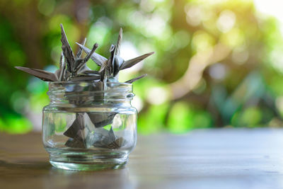 Close-up of origami birds in jar on table