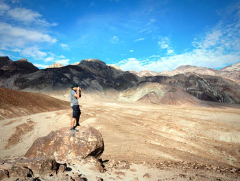 Full length of man standing on mountain against sky