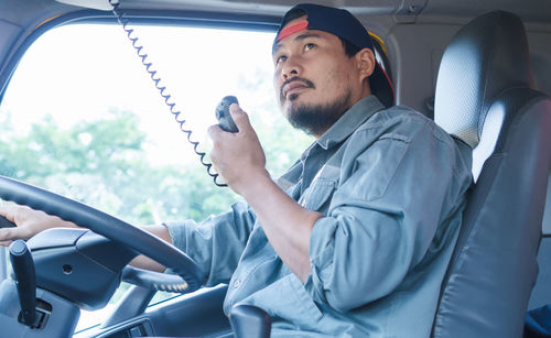 Young man sitting in car