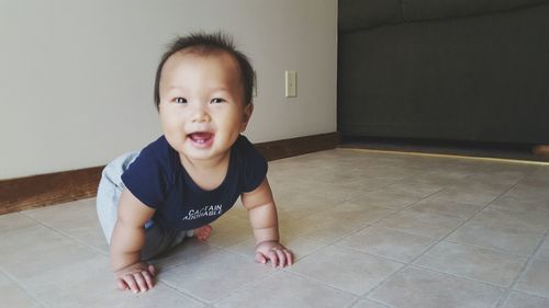 Portrait of happy boy on floor at home