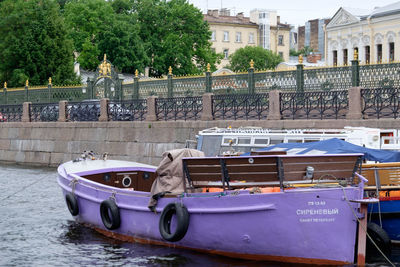 Boats moored in canal by buildings in city