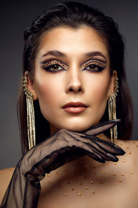 Portrait of young woman against black background