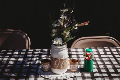 Close-up of flower vase on table against black background