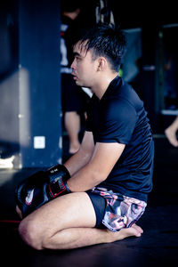 Close-up of boxer looking away while sitting in gym