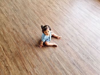 My baby girl sitting on hardwood floor looking up