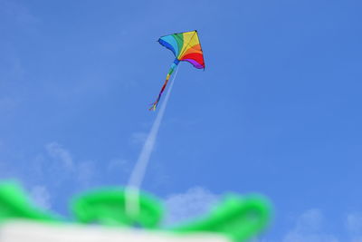 Low angle view of wind turbine against blue sky