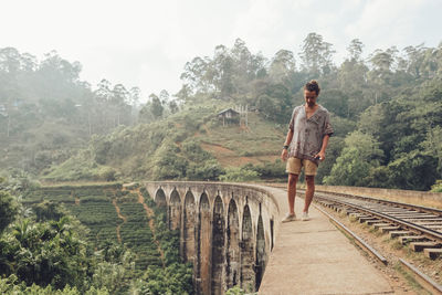 Man standing on railroad track against sky