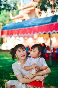 Portrait of smiling mother and daughter in park