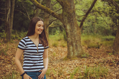 Young woman standing in forest