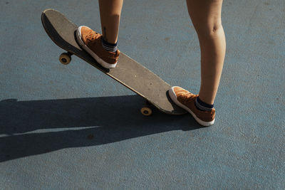 Low section of woman skateboarding on street