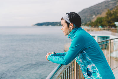 Side view of man looking at sea against sky