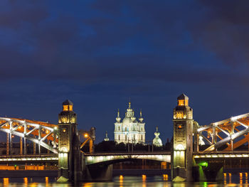 Illuminated bridge over river at night