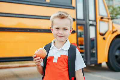 Kid standing by bus on street