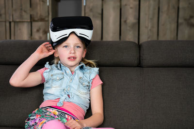 Girl looking away while sitting on sofa