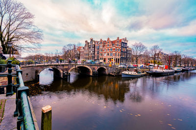 Arch bridge over river against buildings in city