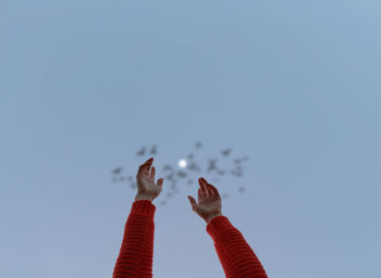 Low angle view of woman flying against clear sky