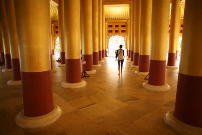 Rear view of woman standing in illuminated building