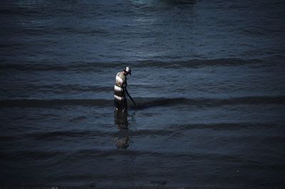 Rear view of man standing in sea